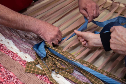 Closeup of hands weaving with ribbon
